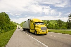 Yellow Semi Truck Travels On Interstate In Springtime