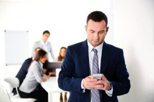 Businessman using smartphone in front of business meeting