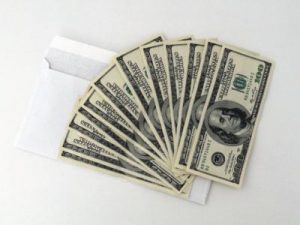 100_dollar_bills_layed_out_over_envolope