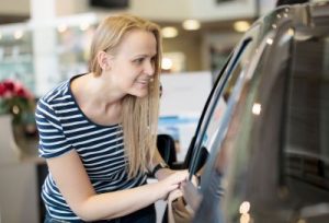 Woman admiring a car at an auto show