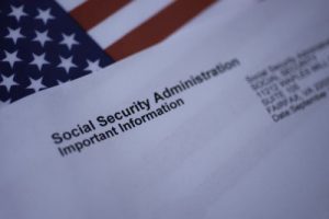Social Security Administration Important Information letter next to flag of USA.